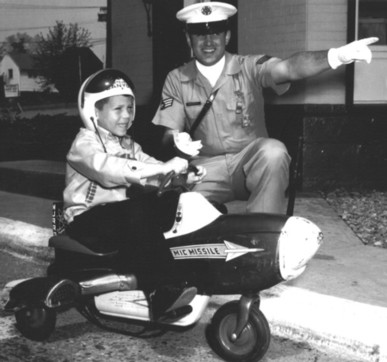 viewers of all ages are expected at Westover Saturday for the annual Armed Forces Day exhibition. One eager visitor is five-year-old Tony Zecchitella, who arrived complete with pedal-powered 'Atomic Missile.' A1C Roger E. Thurston, air ploiceman on duty at the main gate, directs Tony to the display